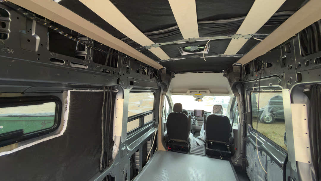 Empty camper van interior with insulated walls and ceiling furring strips ready for a conversion