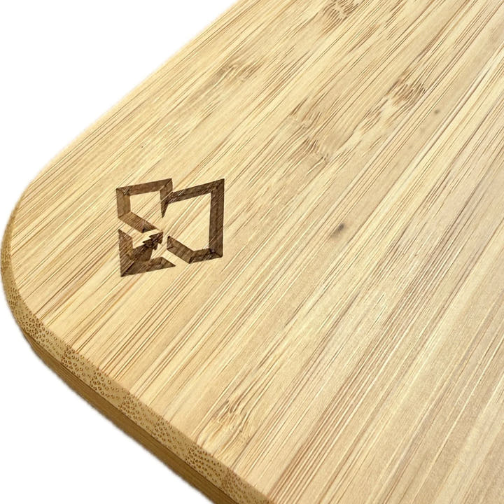 Close-up of a Weekender Outdoors light-colored bamboo camper van table surface with a logo.